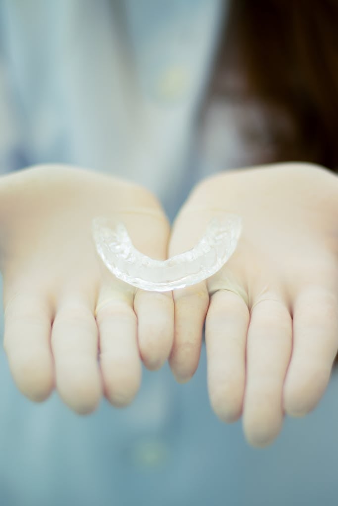 A Clear Retainer on a Person's Hands Wearing Gloves