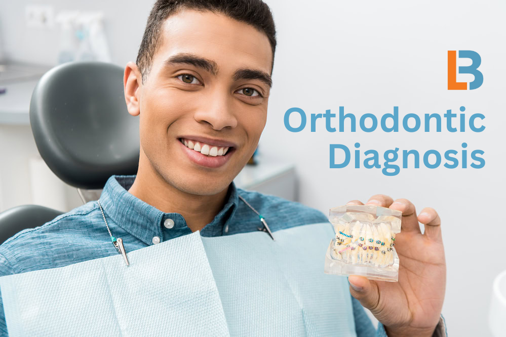 Young man smiling holding a model of teeth with braces, Longmont Braces, orthodontic diagnosis, Colorado